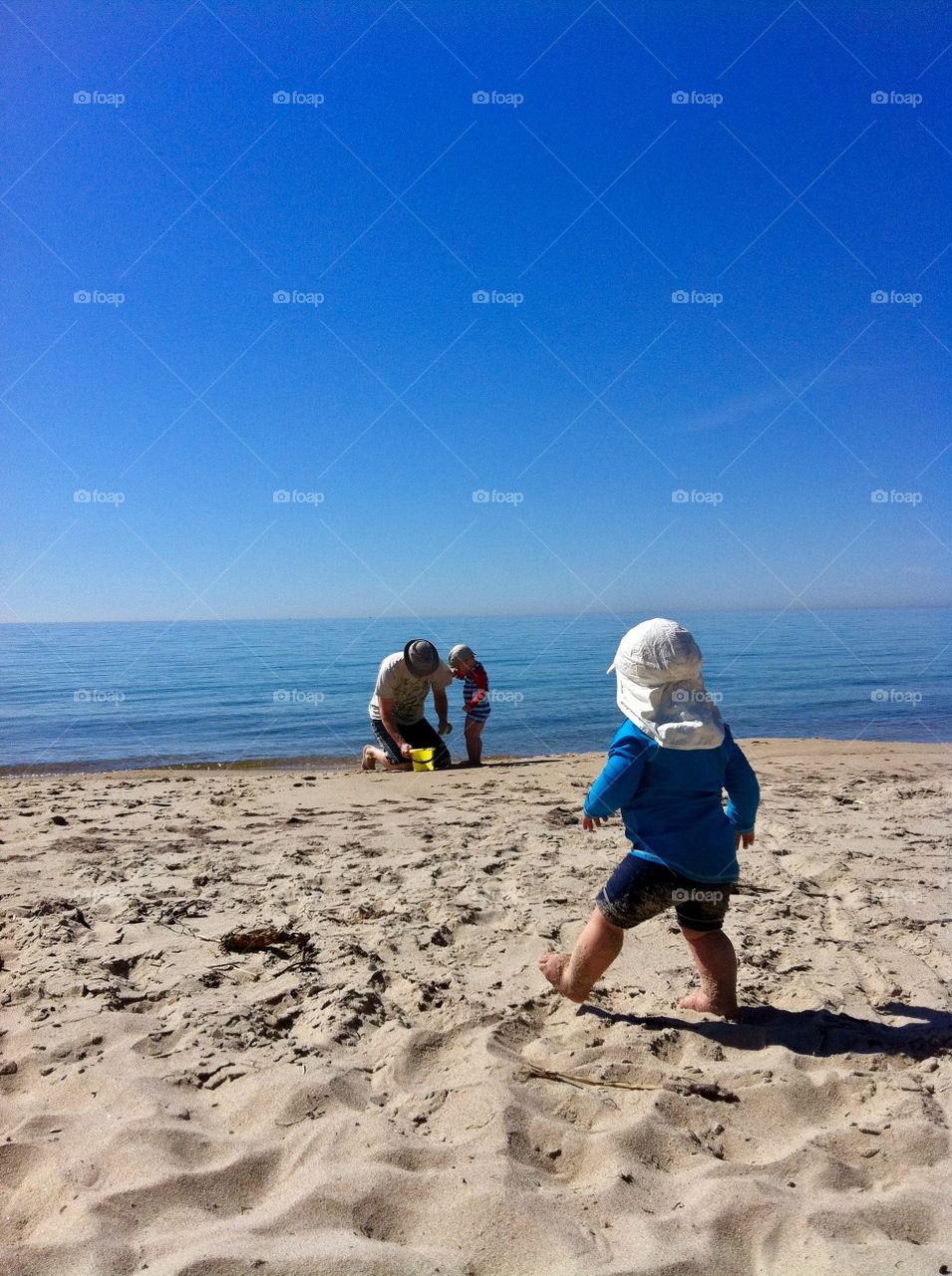 Dad and two kids playing at the beach, sweden