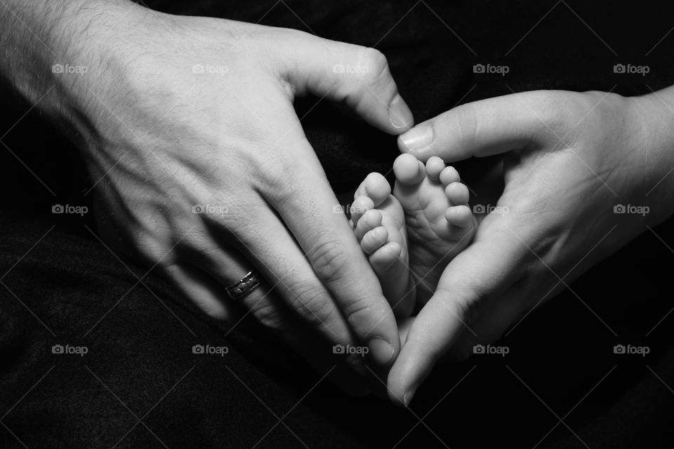 Black and White, parents hands holding infants feet 