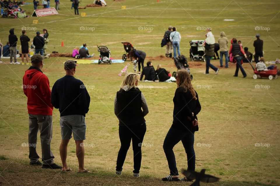 young couple watching weekend game in city park