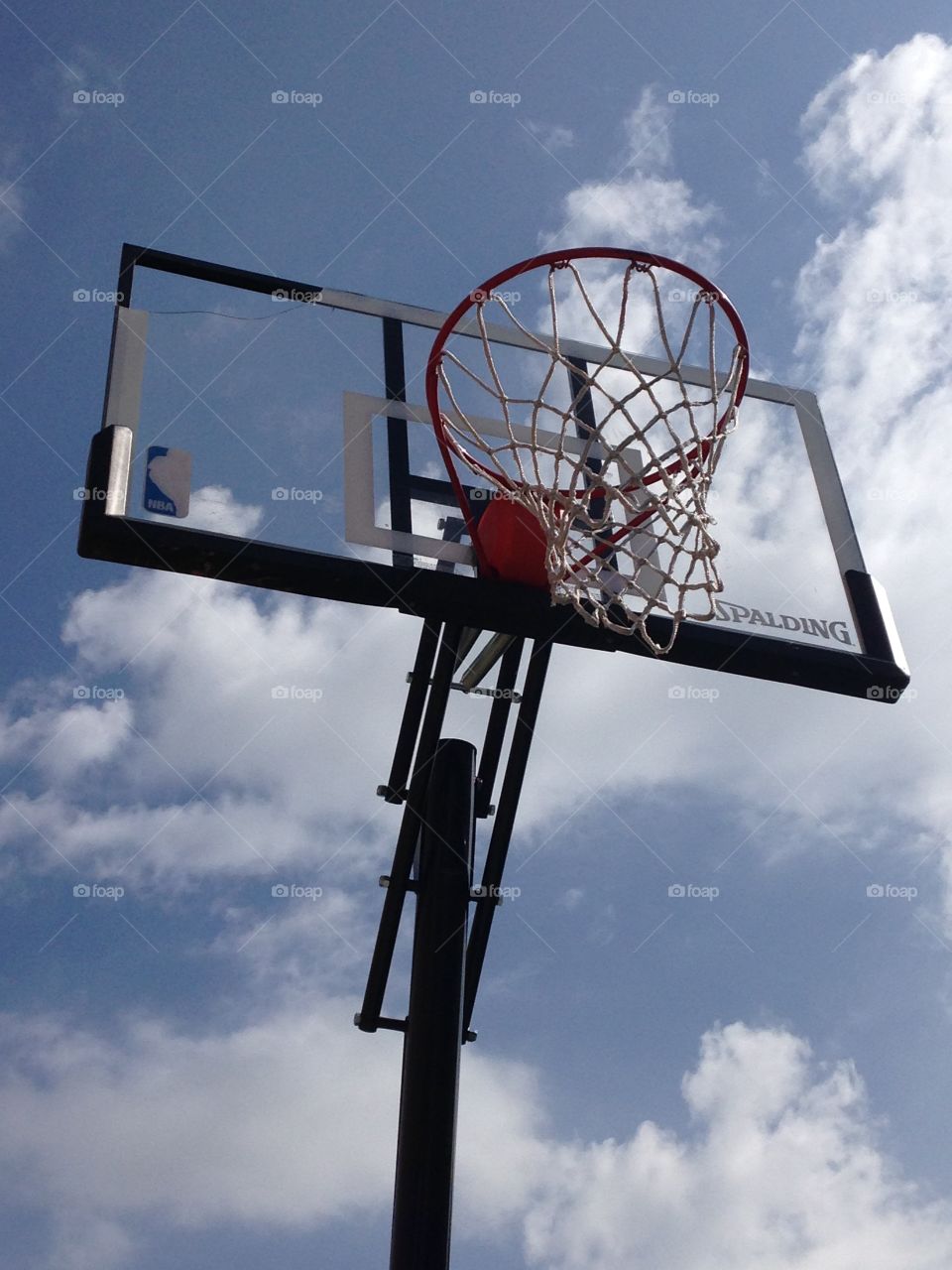 Beautiful day for a game. Basketball goal under a blue sky