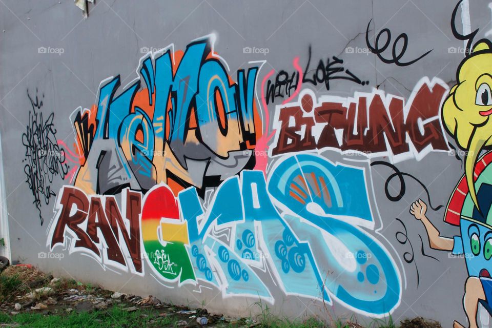 the picture adorns the high wall with various scribbles forming one beautiful work. this is the graffiti on the side of the road boundary