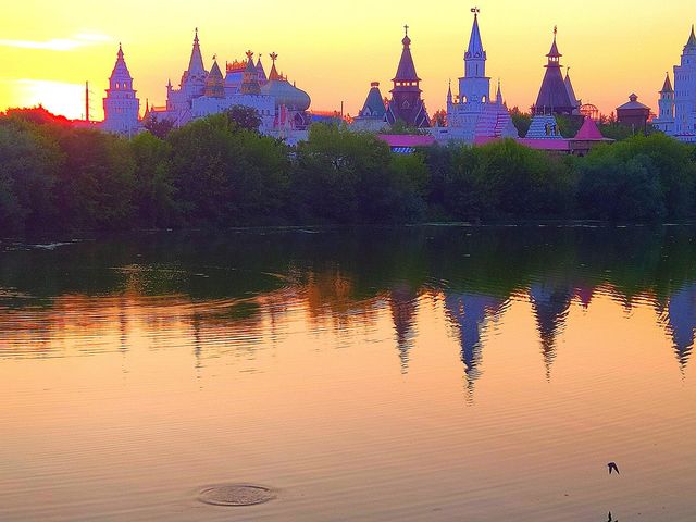 Sunset.  On the water of the river, reflections of the towers of domes and trees.  The domes of the towers at sunset were painted in different shades of purple.  Peace and tranquility of nature