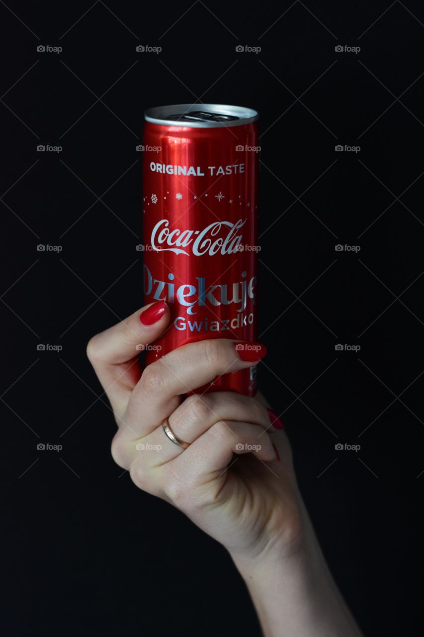 holding cola on black background