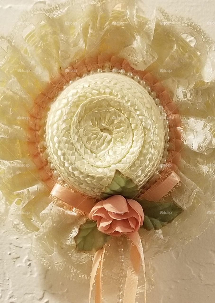 dress hat with peach colored rose sings lace adornments, detailed work, close up