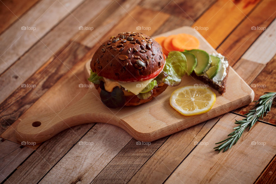 Dark burger with grain bread, cream cheese and avocado