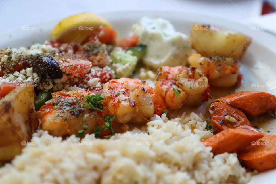 Prawns and scallops suvlakia with rice and tsatsiki - Greek food