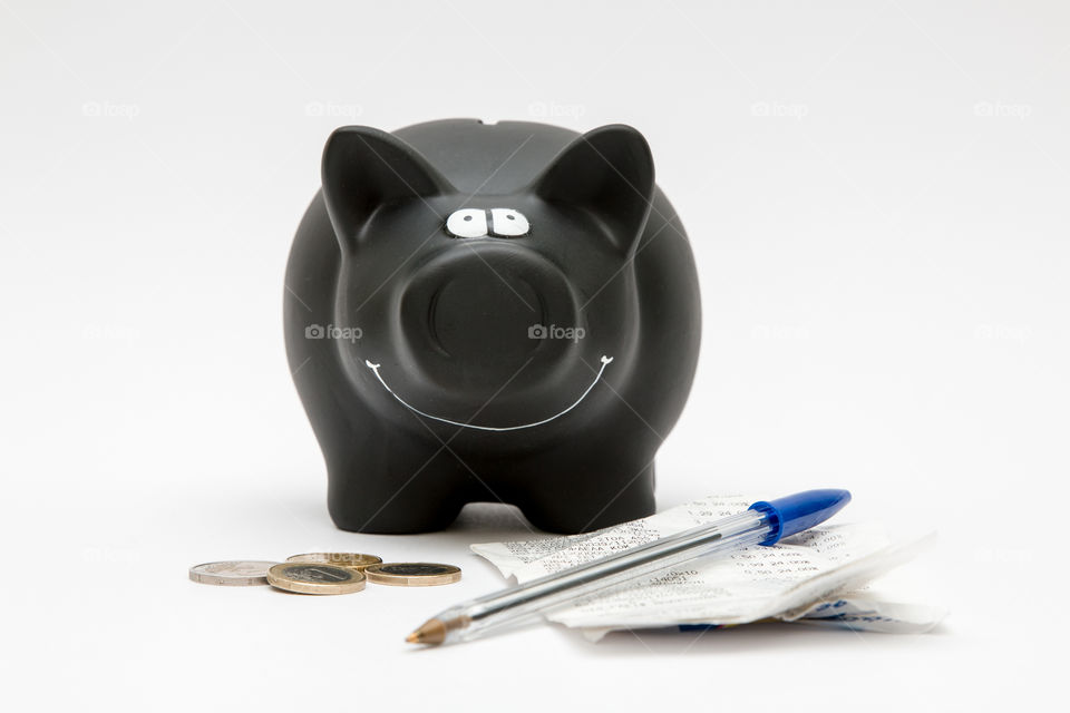 Black Piggy Bank With Coins, Pen And Sales Receipt Isolated In White Background
