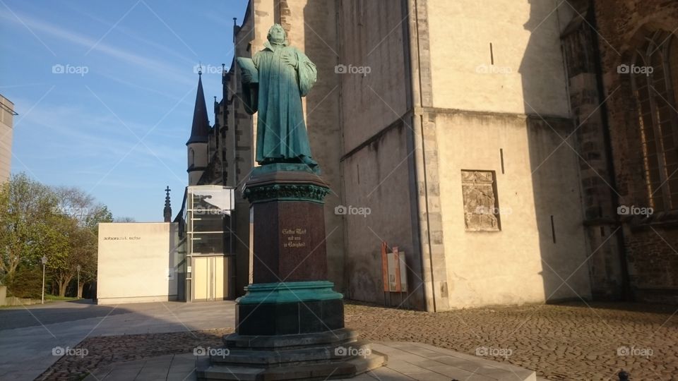A statue of Martin Luther in front of a church