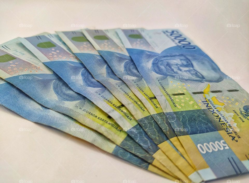 Indonesian currency, several Indonesian 50,000 rupiah banknotes on a white background