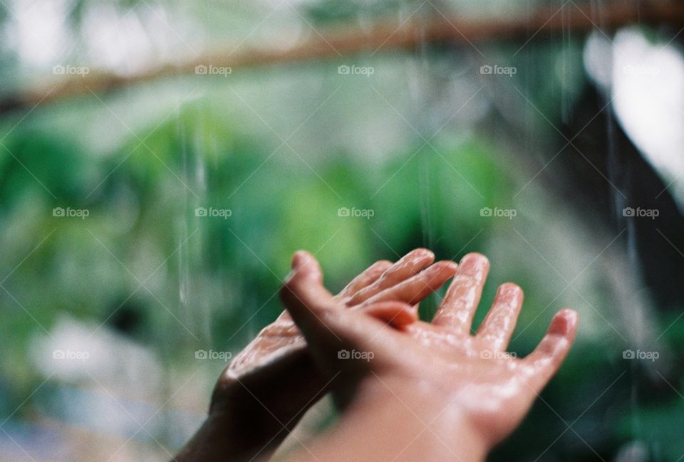 The little boy in the rain, he looks happy.