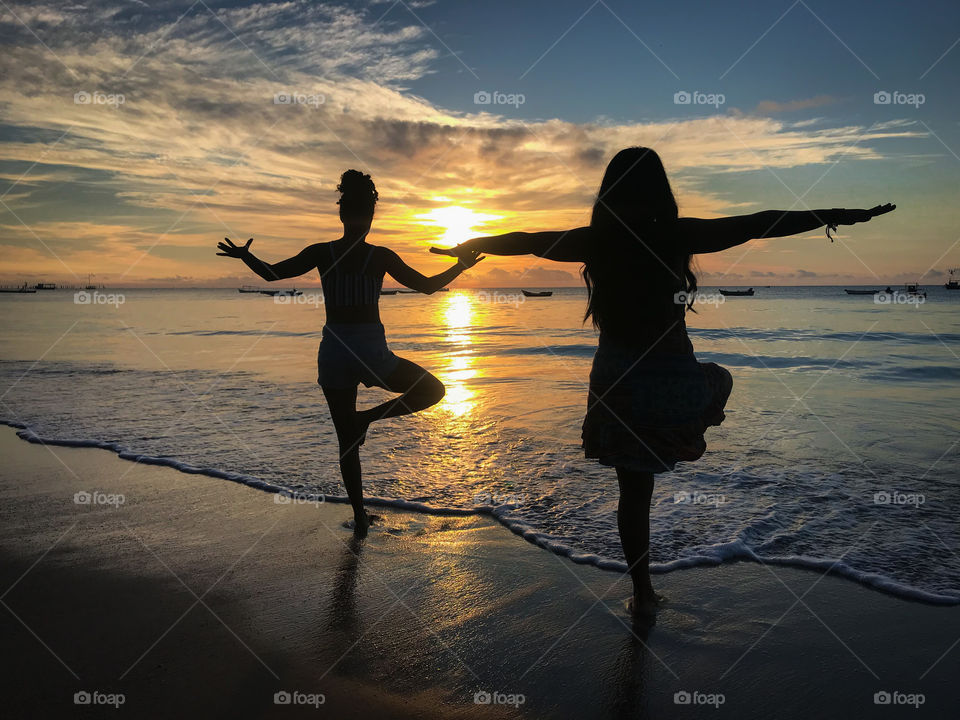 Mãe e filha aproveitando o nascer do sol para relaxar praticando yoga 🧘‍♀️