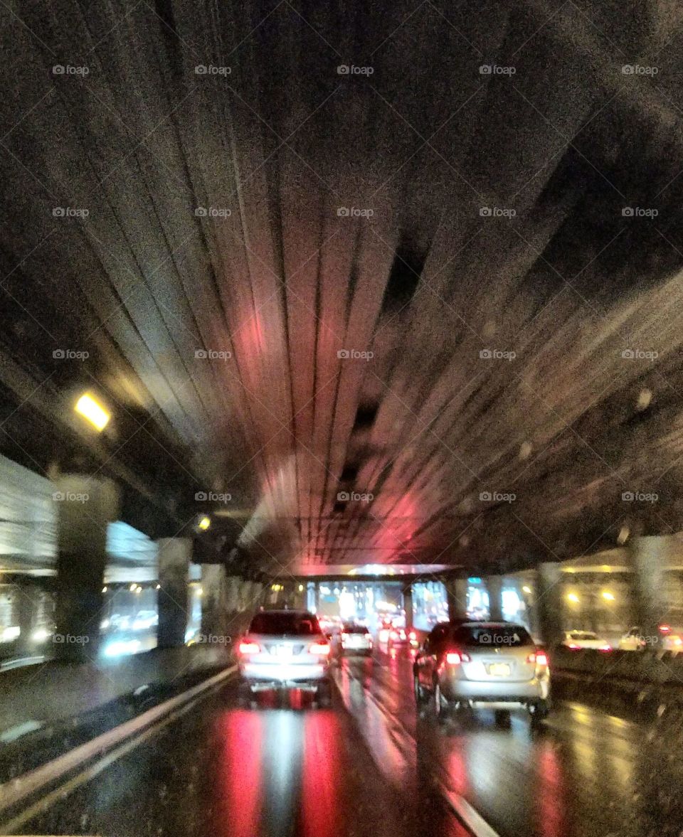 Long Exposure. Driving through long tunnel on highway. Dark inside, exposure showing streaks of light.
