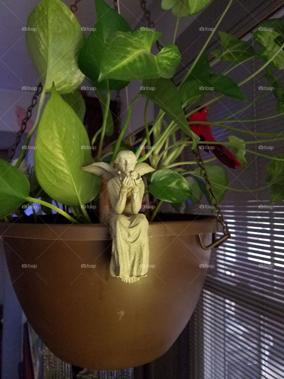 Angel sitting on potted plant.