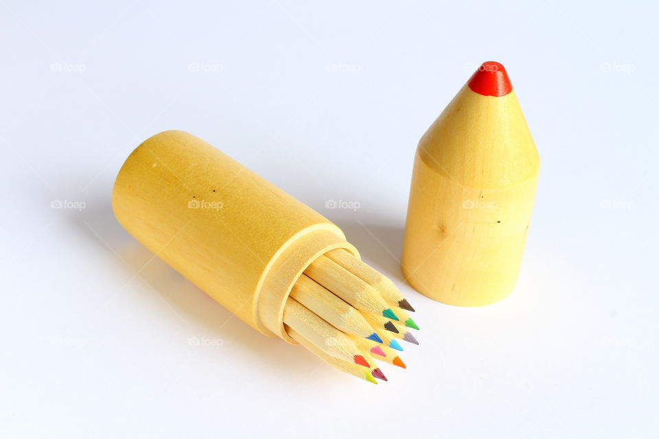 Group of color crayons in a wooden cylinder isolated macro