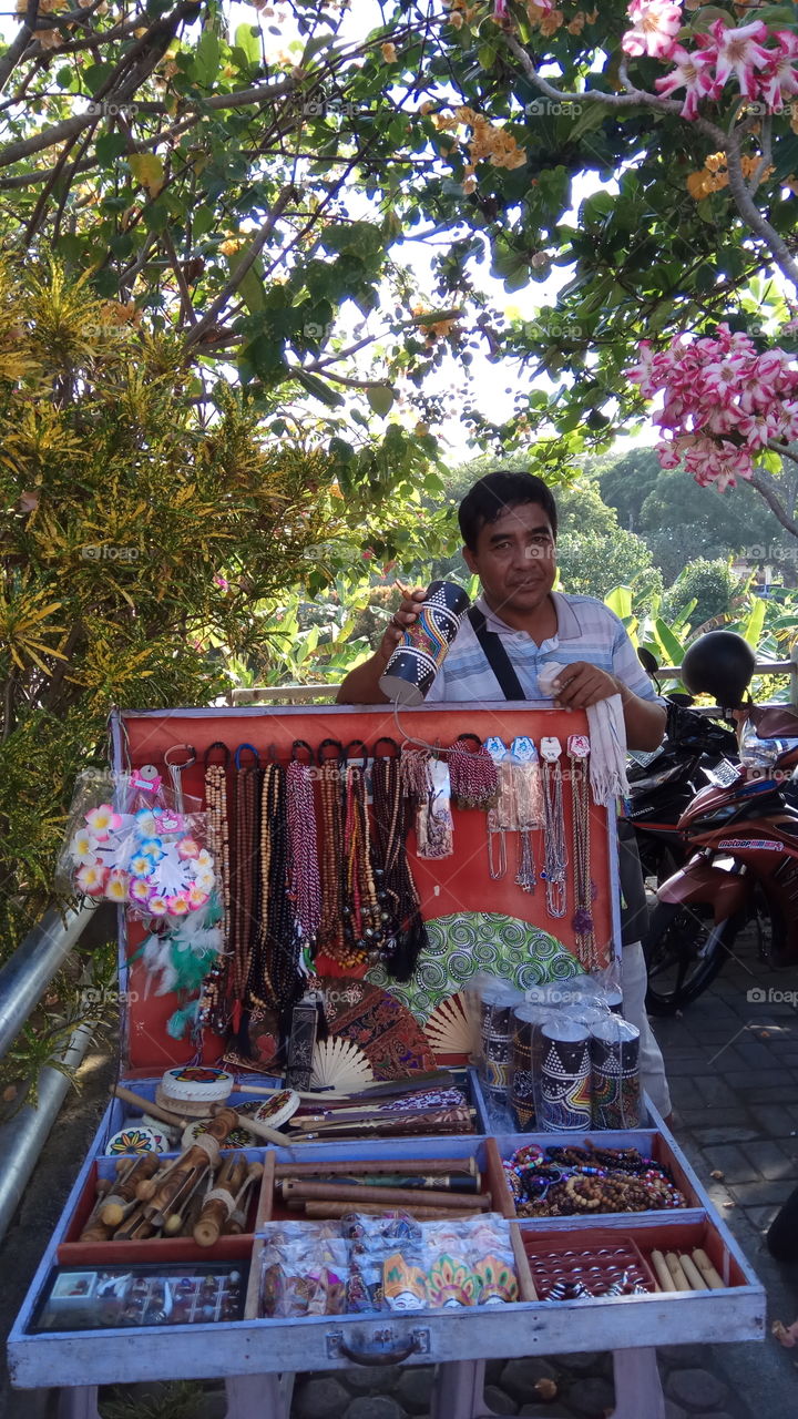 Indian man selling wooden equipment