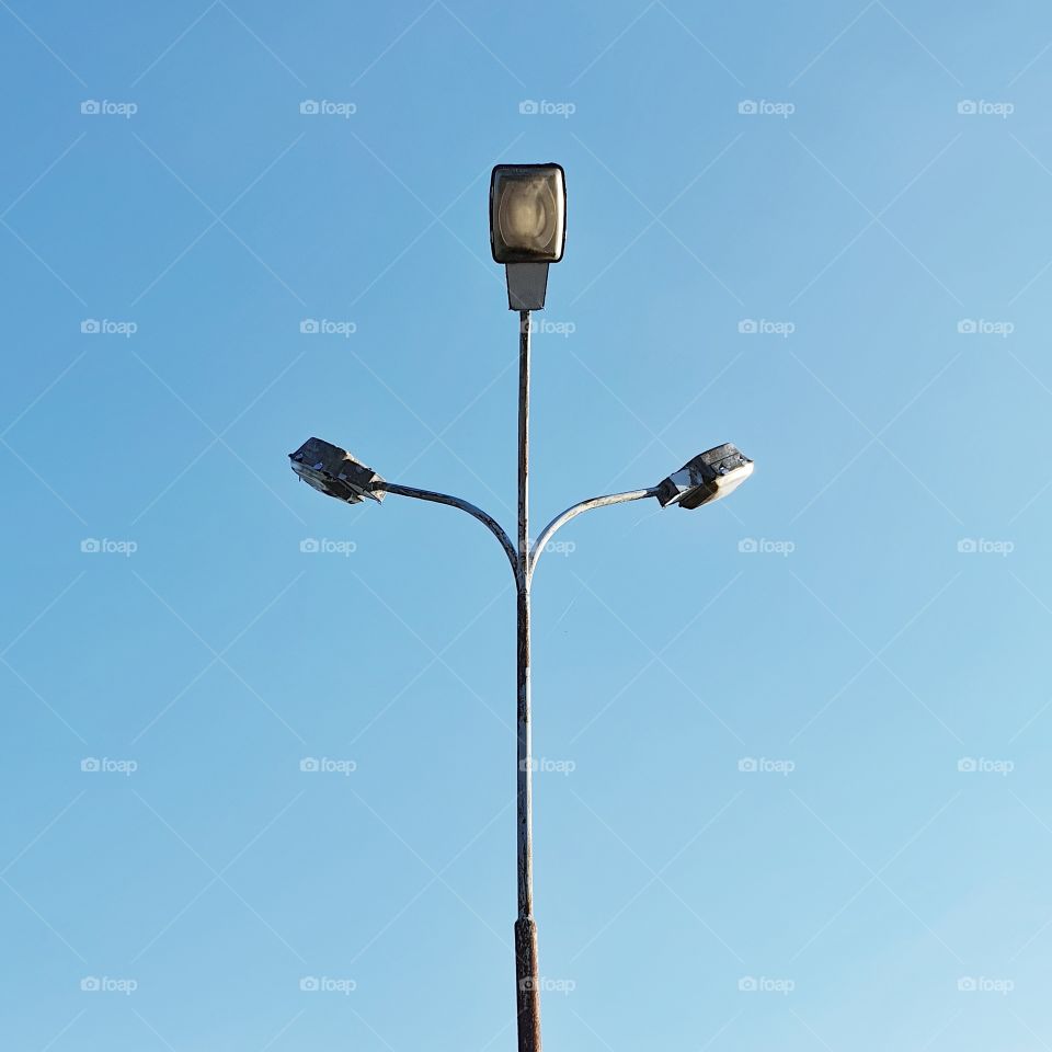 Lamppost with three lamps, upwards against a blue sky