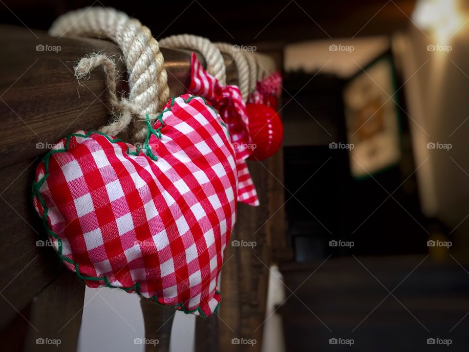 Wooden railing decorated with hearts and Christmas globes in winter