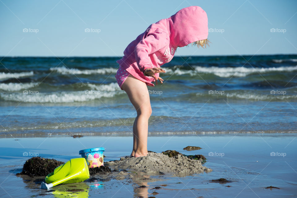 Three year old little girl playing at the beach in Höllviken in Sweden.