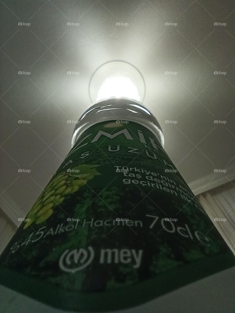 A special photo of alcoholic drink bottle with ceiling and room light