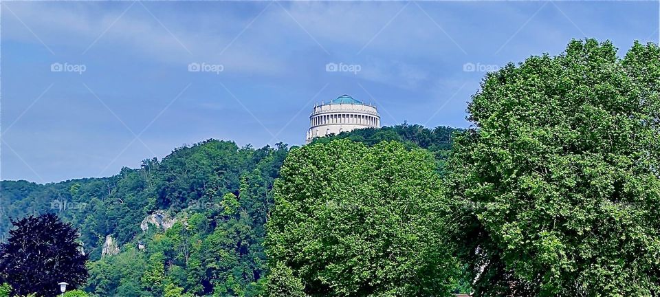 Up there on this forested hill we see the Greco-Roman structure of “Liberation Hall” at “Kelheim”, Bavaria on the “Danube” built in 1815 by King “Ludwig I” to honor the victorious fighters against “Napoleon”. 2024. Hypnotic Productions