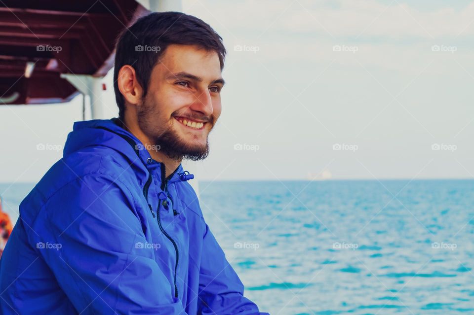 A young sailor in the black sea rejoices and enjoys the seascape