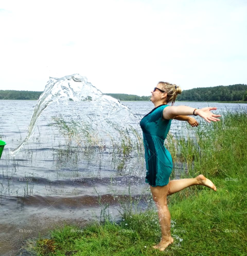 девушка с всплеском воды на нее,на природе