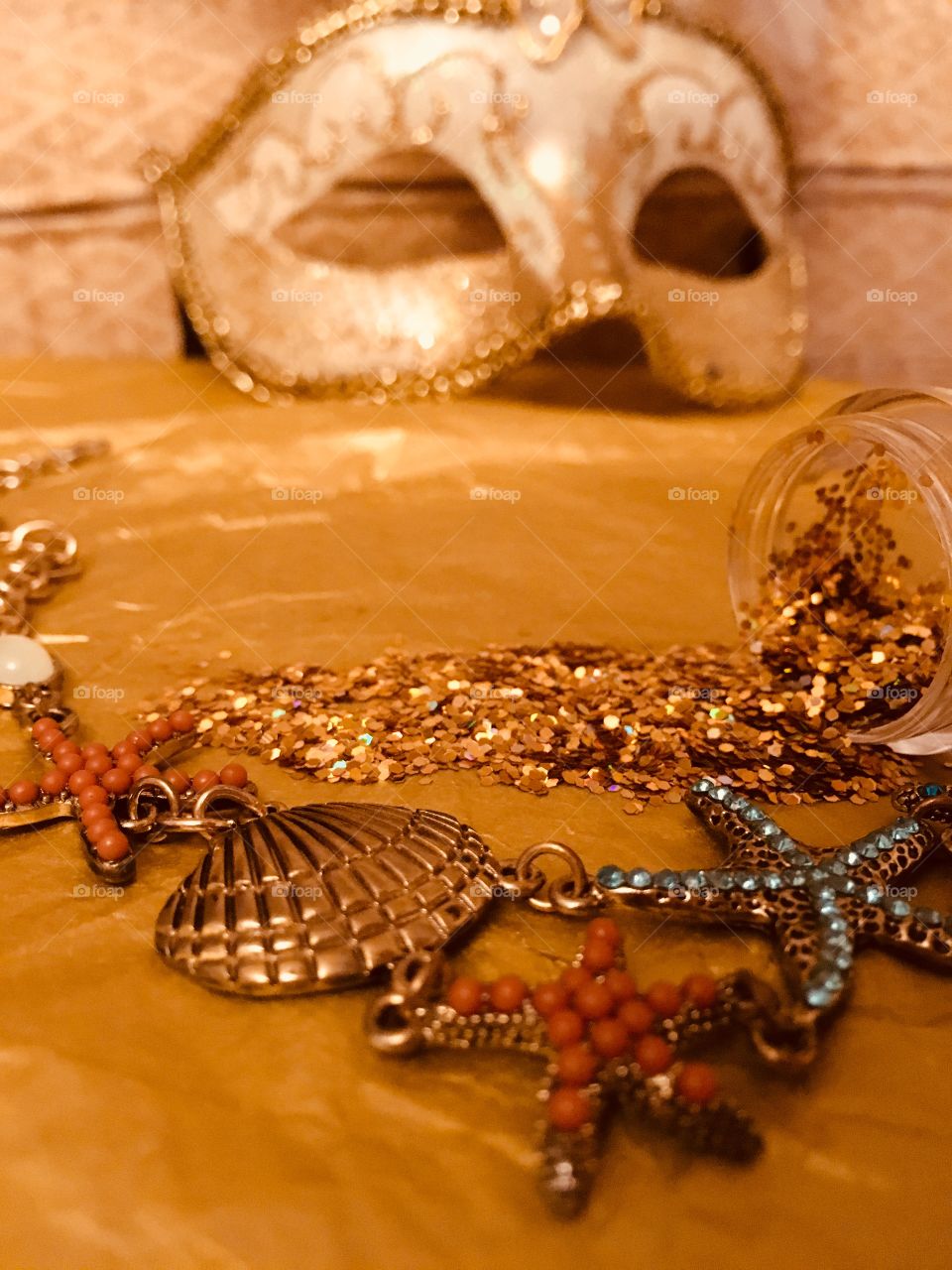 Seashore themed gold necklace with shells and starfish with spilled gold glitter and Venetian masquerade mask 