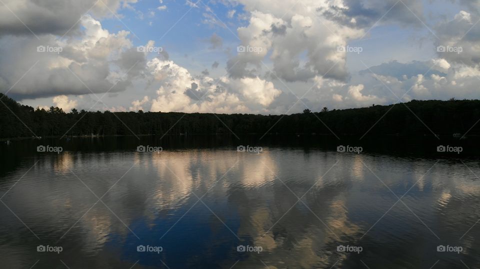 An evening on the calm lake with clouds overhead.