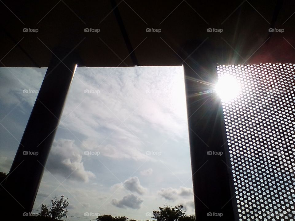 Sunlight and clouds behind the architectural buildings in the park