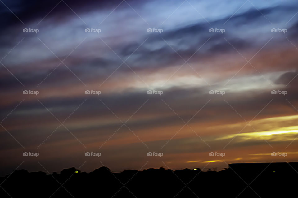 Beautiful light of Sunset with clouds in the sky reflection behind the building.