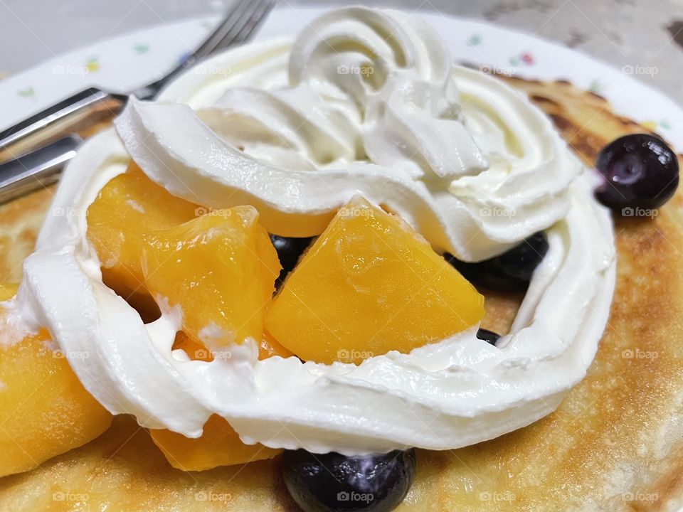 Pancake with diced mangos,blueberries,and whipped cream