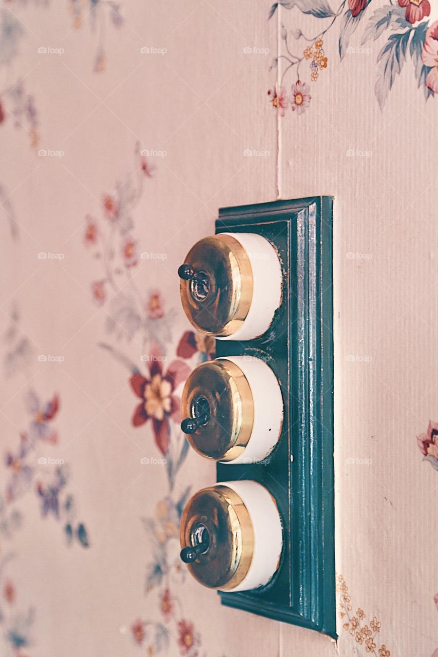 Beautiful wallpaper and vintage switches in focus