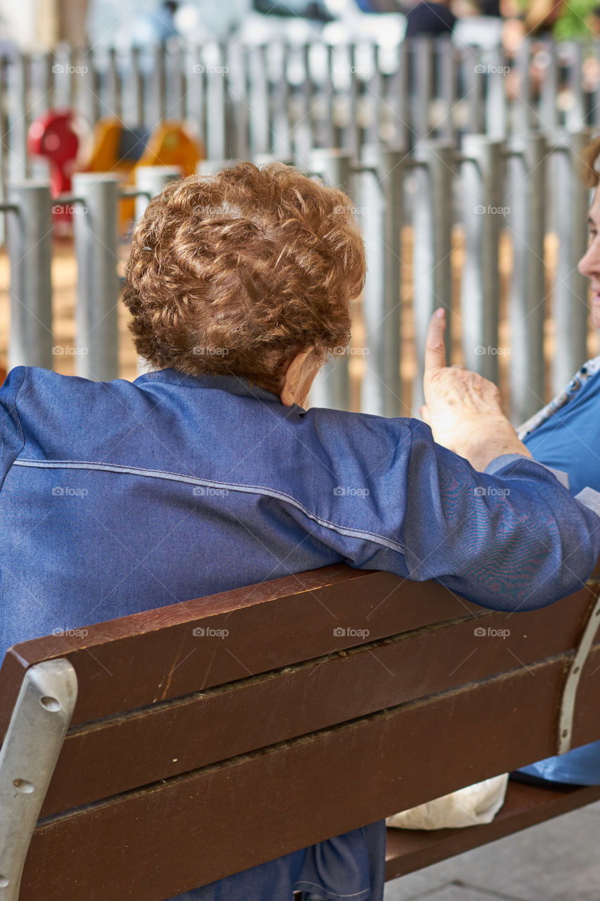 Elderly woman talking with a friend at a square