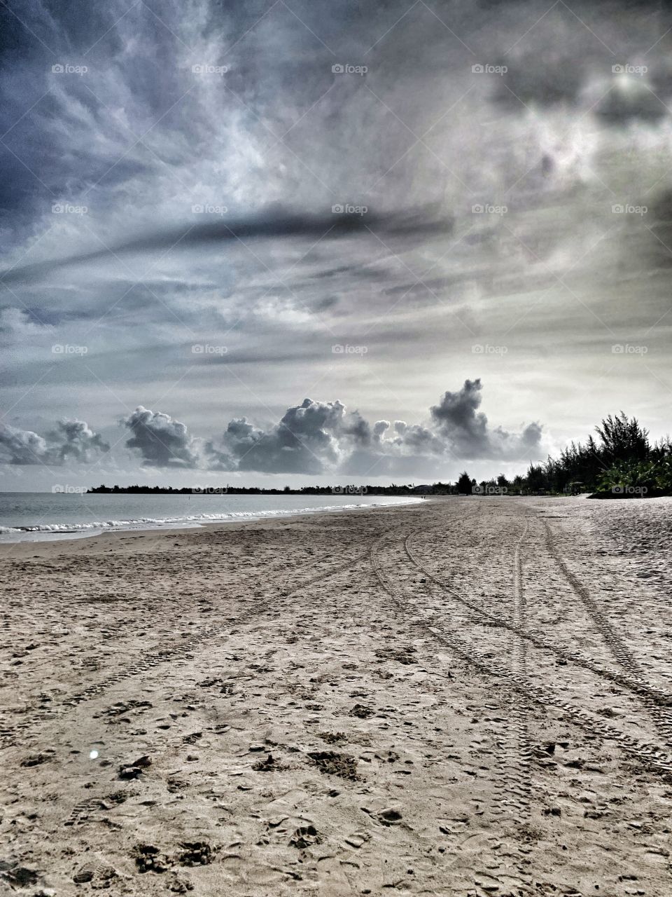 Beautiful clouds , sky, sea and sand. Nature’s beauty. Marks of a vehicle. Peaceful area. 