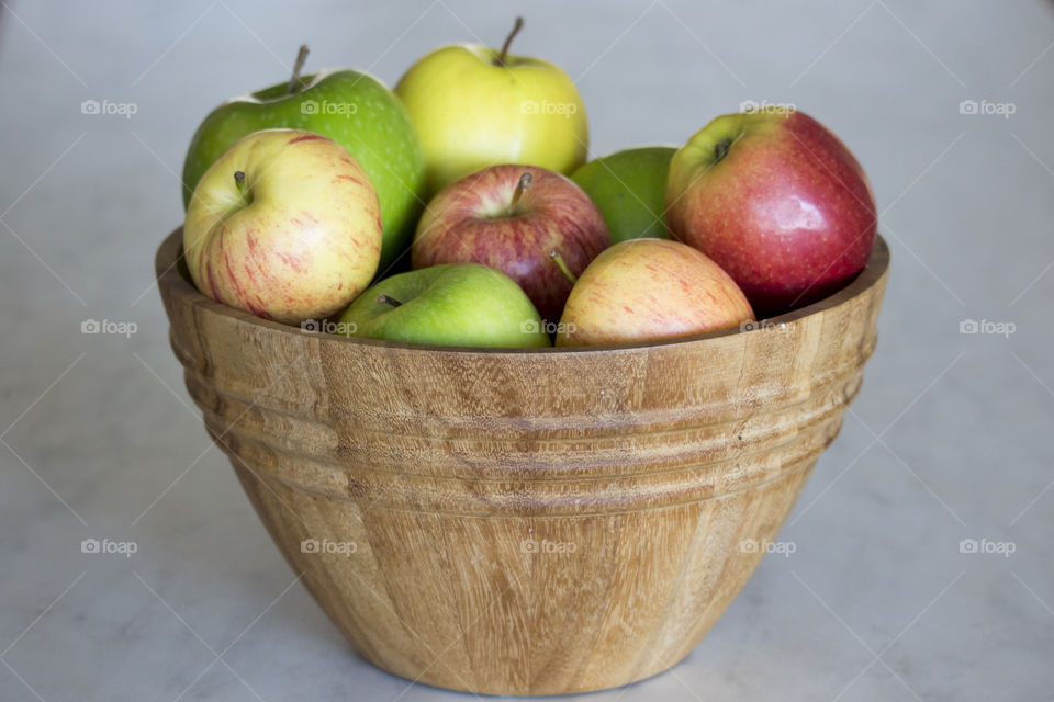 Apples different colors in wood bowl 