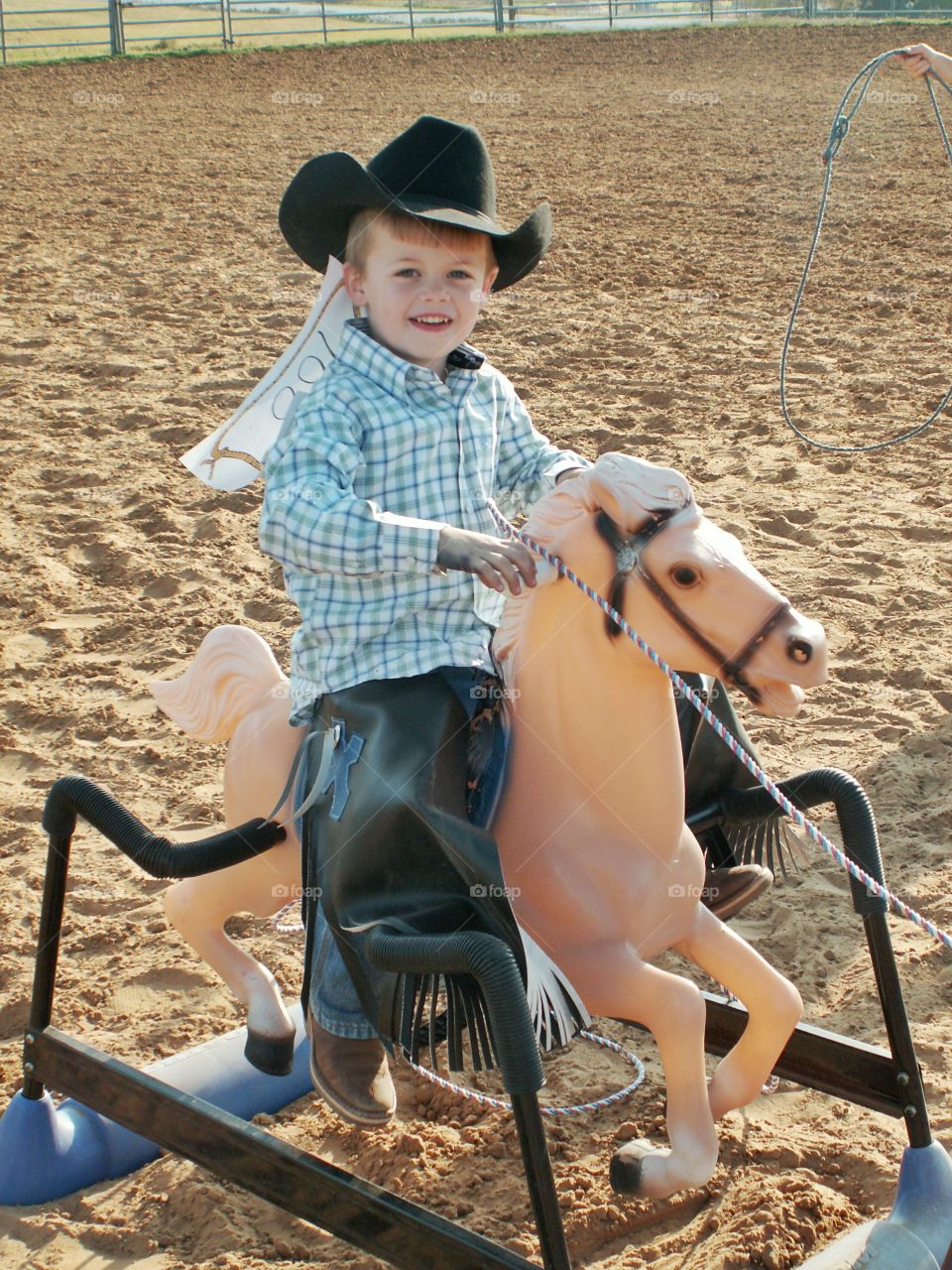 Happy boy sitting on toy horse