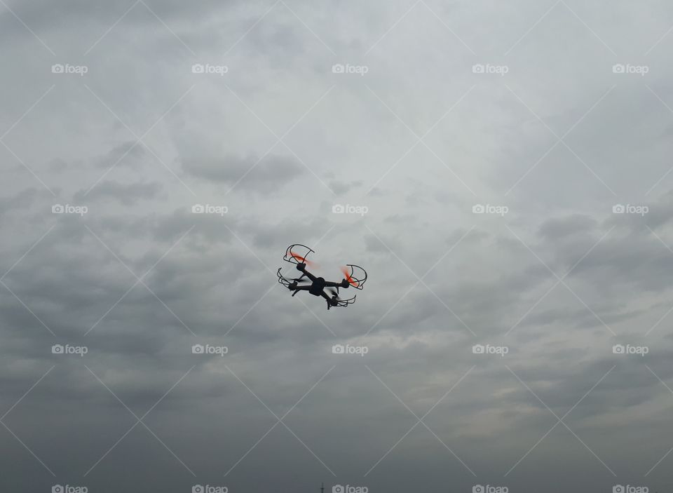 Drone flying in the grey sky