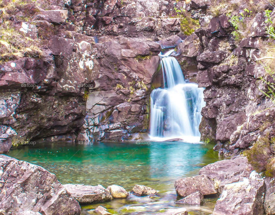 Fairy Pools on the Isle of Skye, Scotland feature clear blue water pools and waterfalls in the craggy rock.