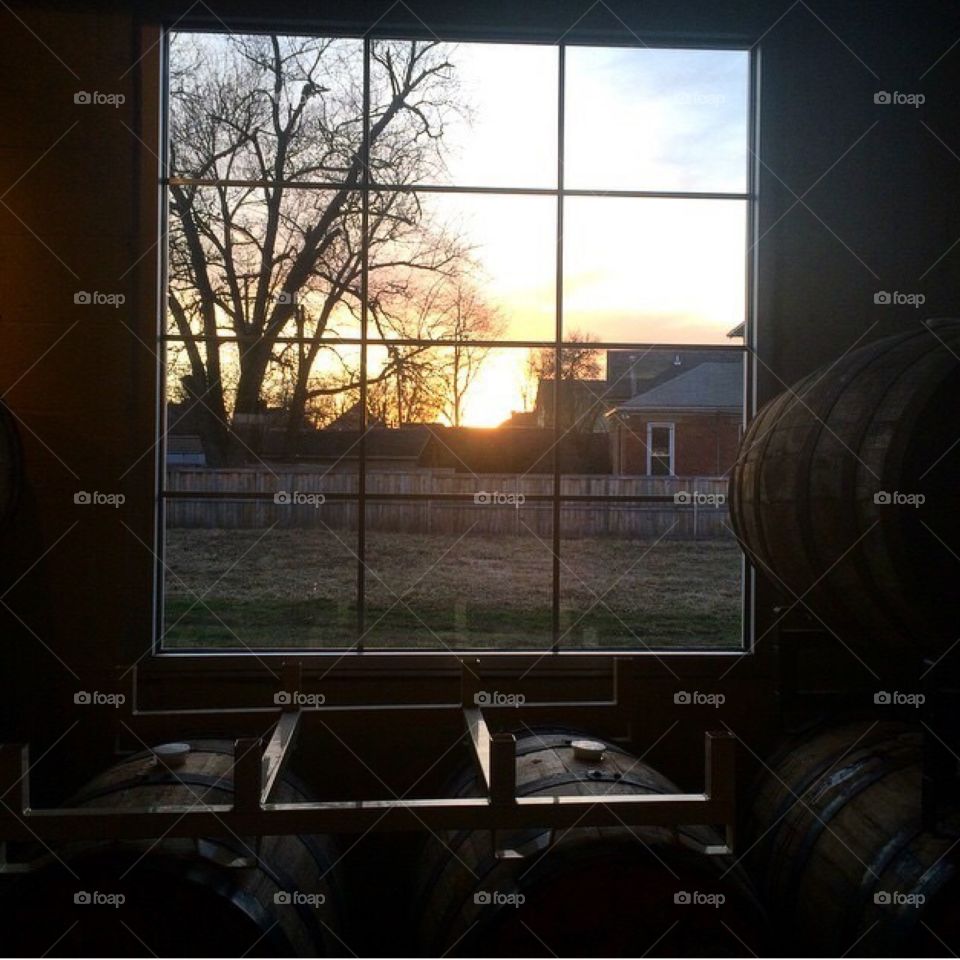 Golden Hour at Seventh Son . Beer barrel room with image of sun setting outside of framed window