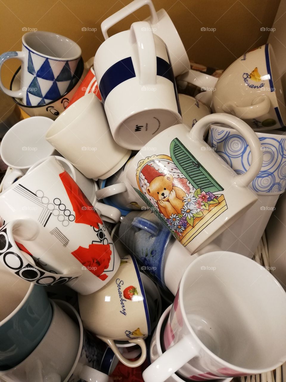 Plenty of coffee and tea cups one on the other in the basket on the table.