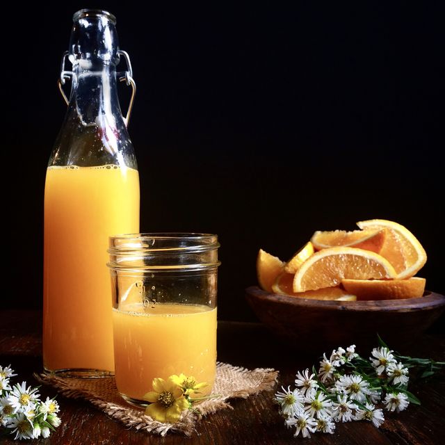 Fresh homemade orange juice with orange wedges in bowl