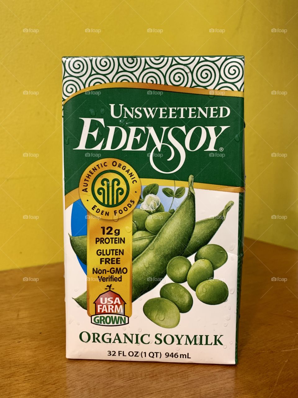 Unsweetened organic soymilk with 12 gram of protein, gluten free and non-gmo. With brown and yellow background.