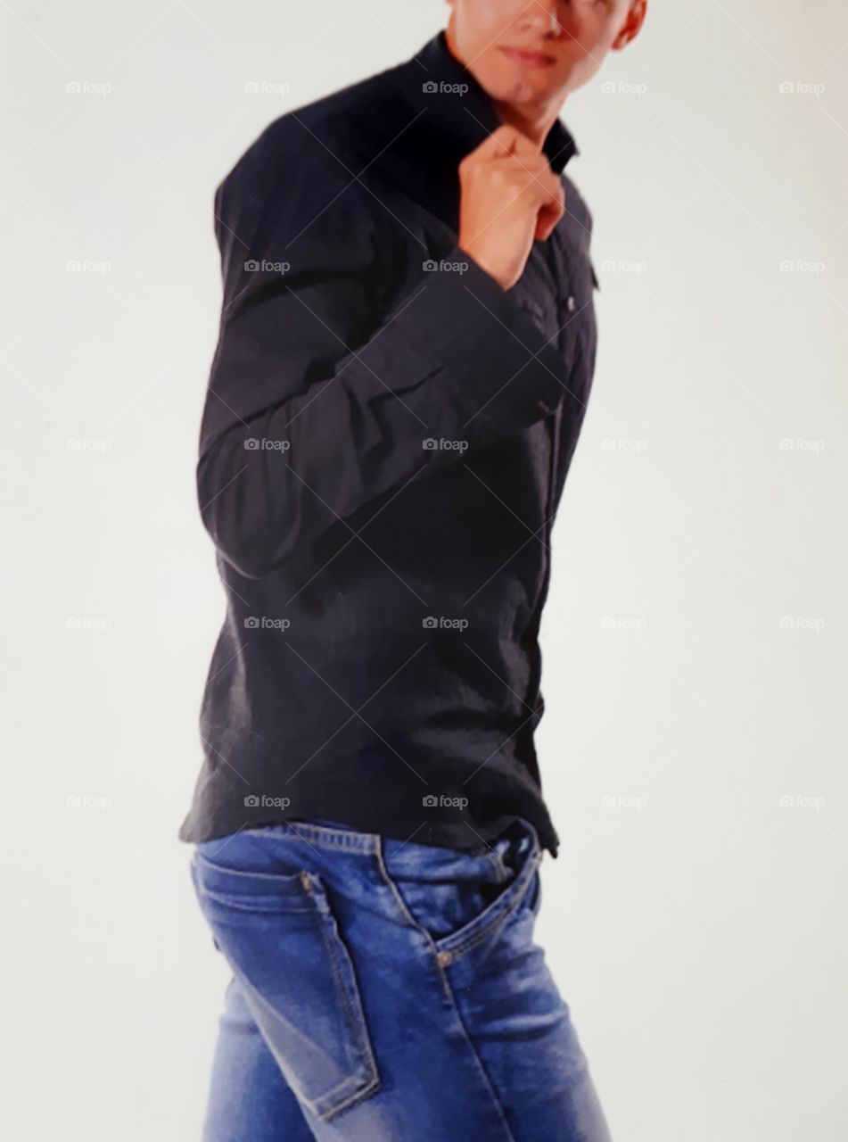 Young man dressed in black shirt and denim pants