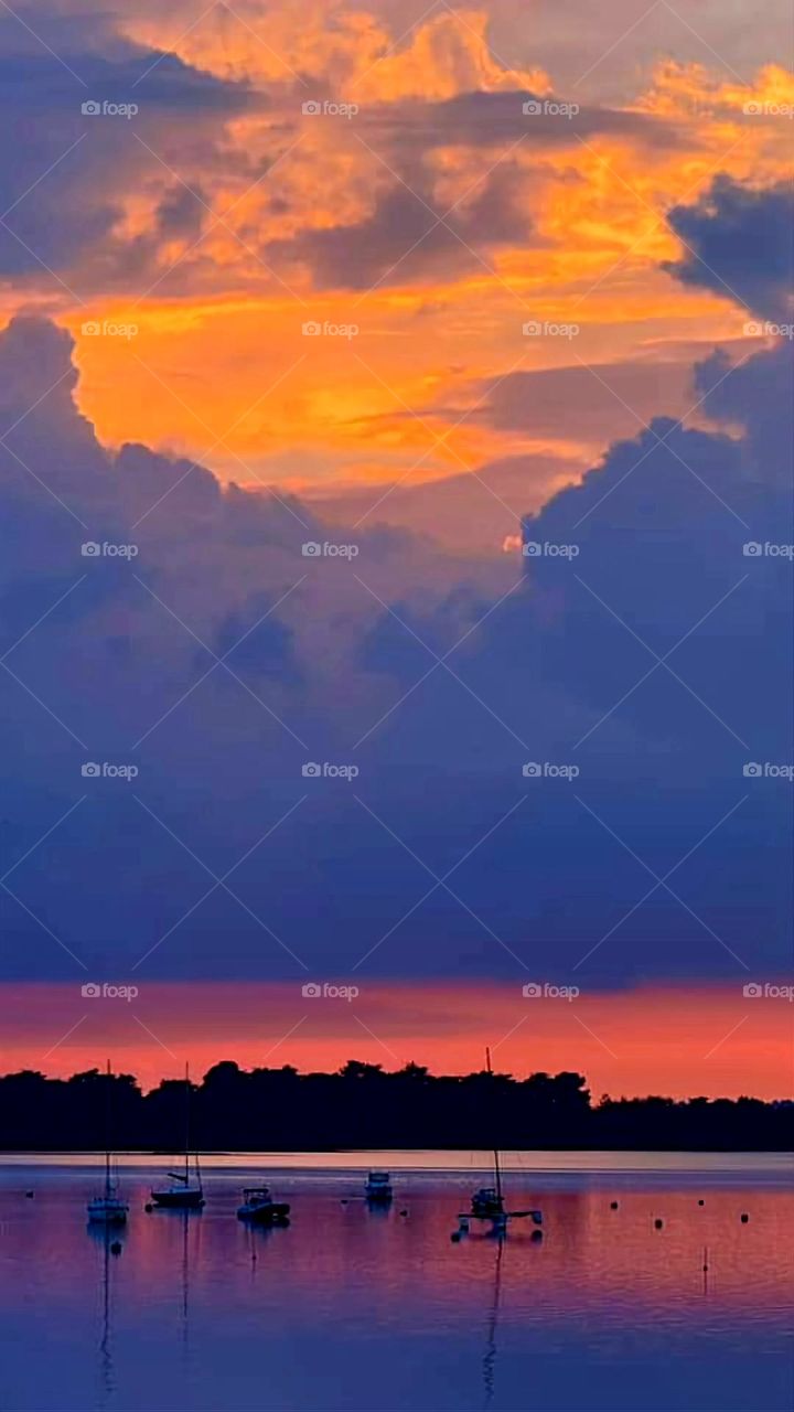 Blue and orange sunset over Sarzeau's sea and sailboats at low tide