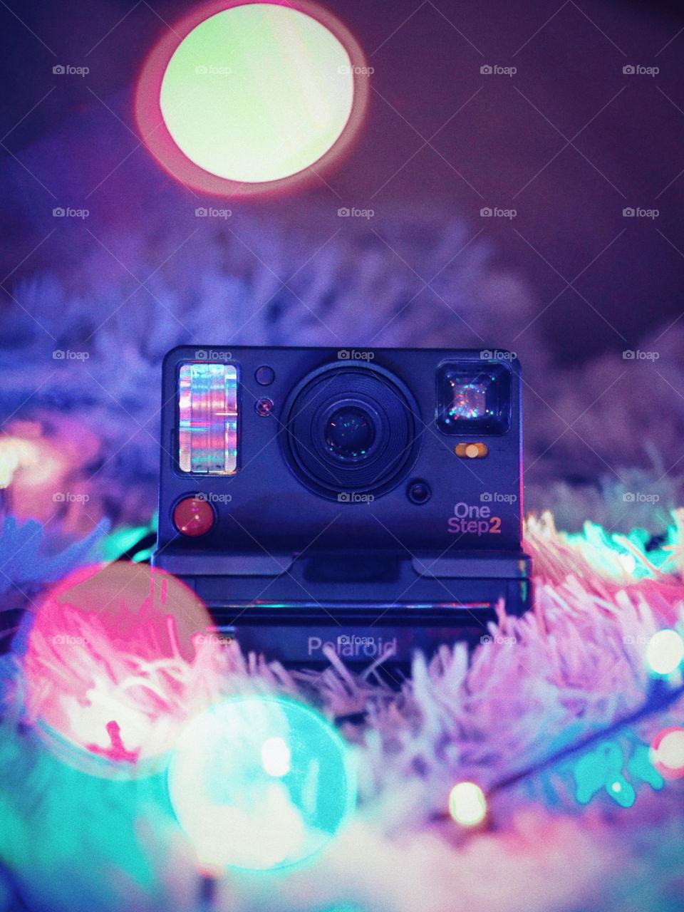 A photo of my first polaroid camera in Christmas lights.