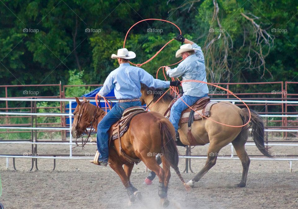 Two rodeo riders in a practice corral before competing