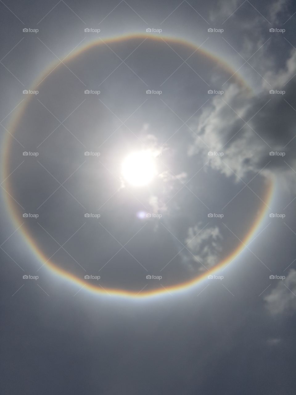 circle rainbow aura full spectrum around the sun in the sky