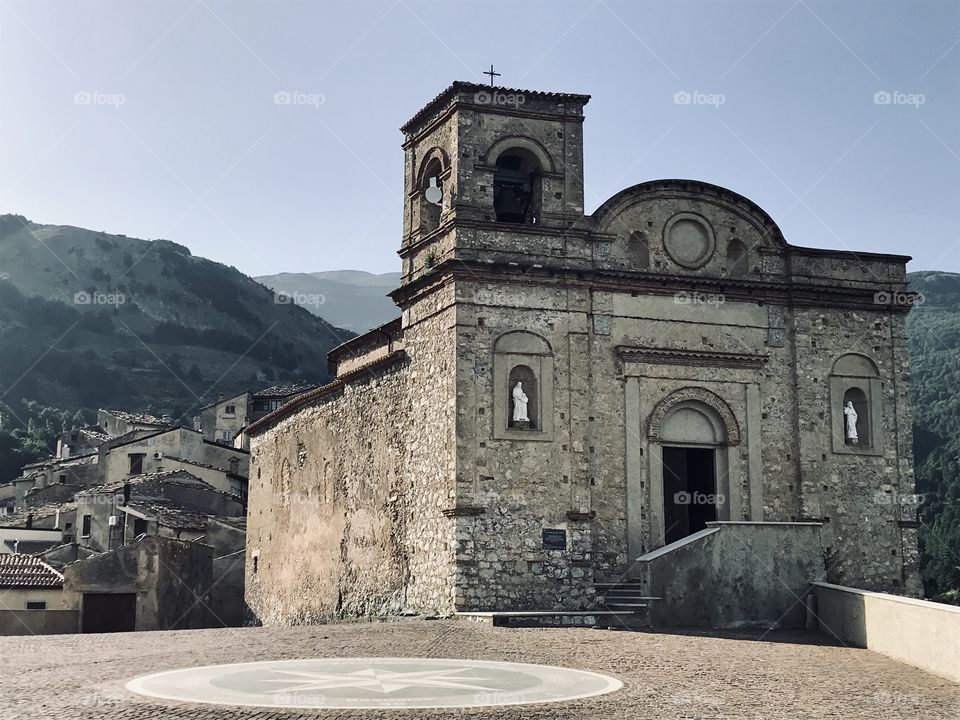 Chiesa dell’Assunta (Assunta Church), built around 1000 a.D. in San Donato di Ninea, and part of the village which is now mostly abandoned in the background. Calabria, South Italy 