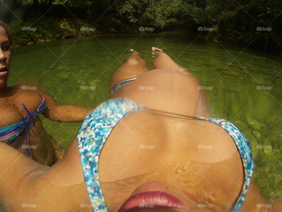 pregnant woman showing her baby hump while floating in a river