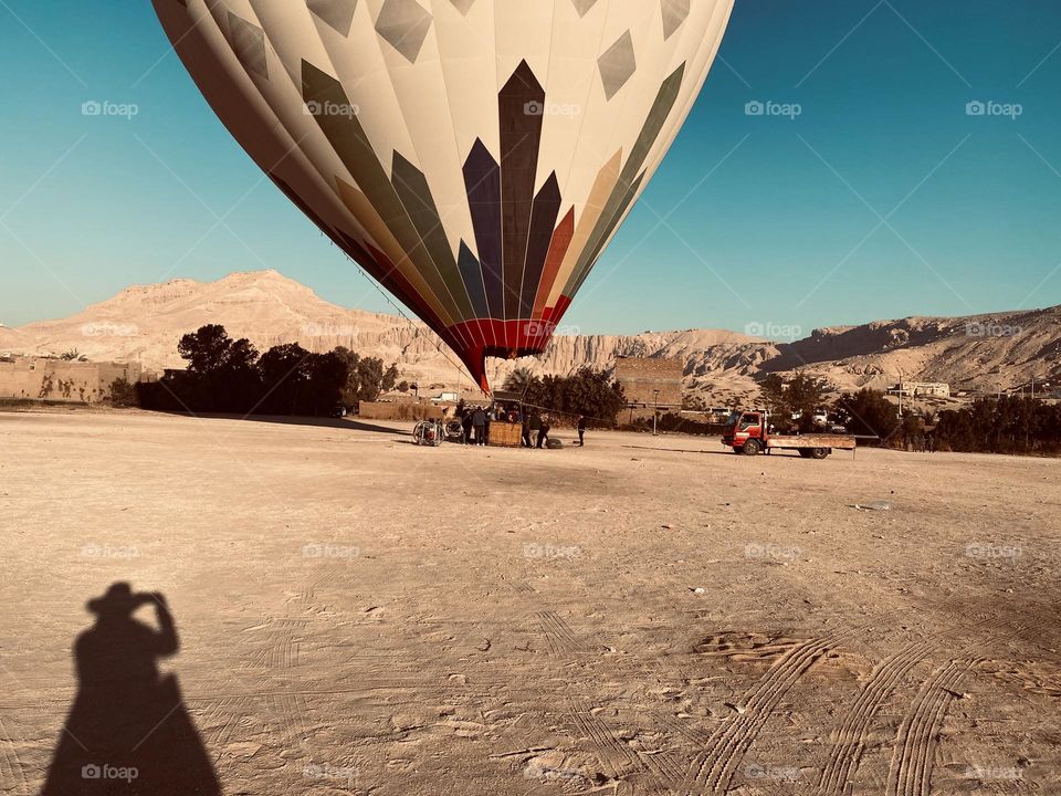 The shadow of a girl who is taking pictures for hot air balloon